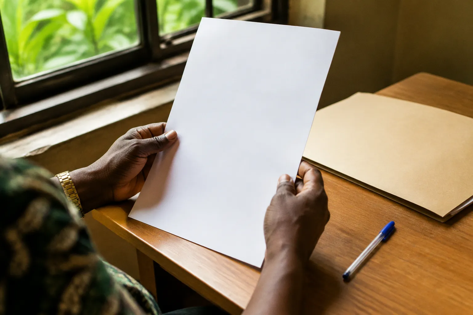 Mains tenant un document administratif au-dessus d’un bureau clair
